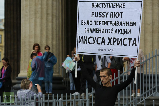 Artist Pyotr Pavlensky holds a board in support of jailed members of female punk band "Pussy Riot" with his mouth sewn shut during a protest outside the Kazan Cathedral in St. Petersburg. (REUTERS / Trend Photo Agency / Handout)