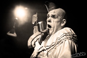 A clown leading the crowd in a rendition of the national anthem.