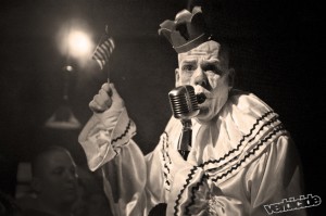 A clown leading the crowd in a rendition of the national anthem.